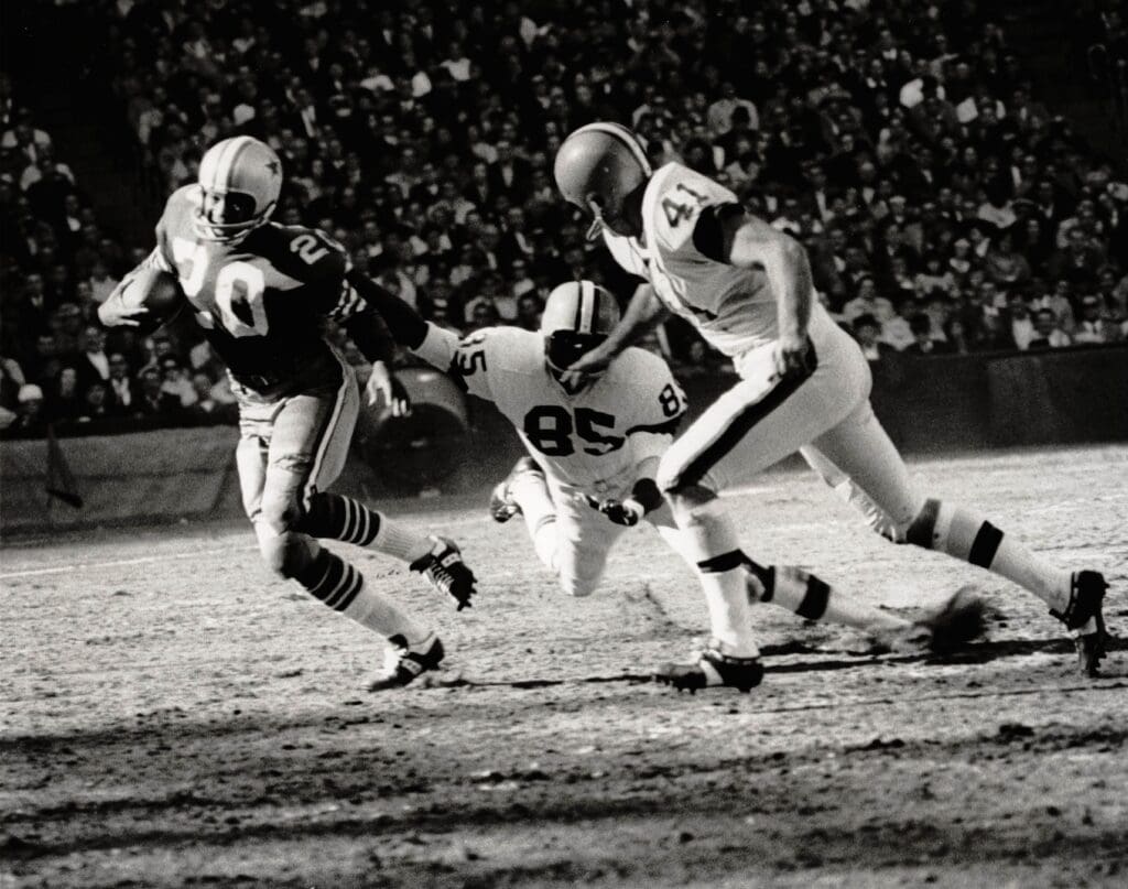 Unknown date; Cleveland, Ohio; Dallas Cowboys cornerback #20 Mel Renfro eludes the tackle of Cleveland Browns wide receiver #85 Clifton McNeil and tight end #41 Ralph Smith. Renfro intercepted 52 passes during his 14-season Hall of Fame career.