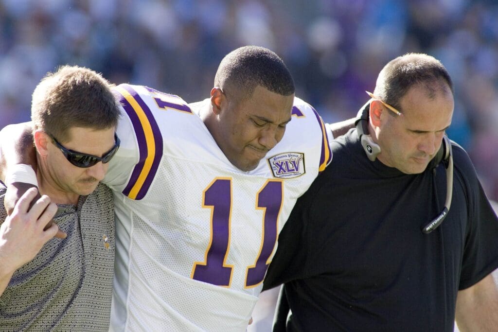 October 30, 2005; Charlotte, NC, USA; Minnesota Vikings quarterback #11 Daunte Culpepper is helped off the field by a trainer and head coach Mike Tice after getting injured in the first half against the Carolina Panthers at Bank of America Stadium.