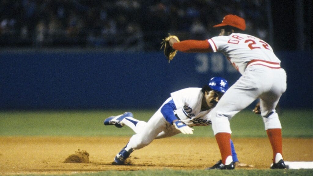 1977; Los Angeles, CA, USA: FILE PHOTO; Los Angeles Dodgers second baseman Davey Lopes slides into first base as Cincinnati Reds first baseman Dan Driessen tries to make the tag at Dodger Stadium.