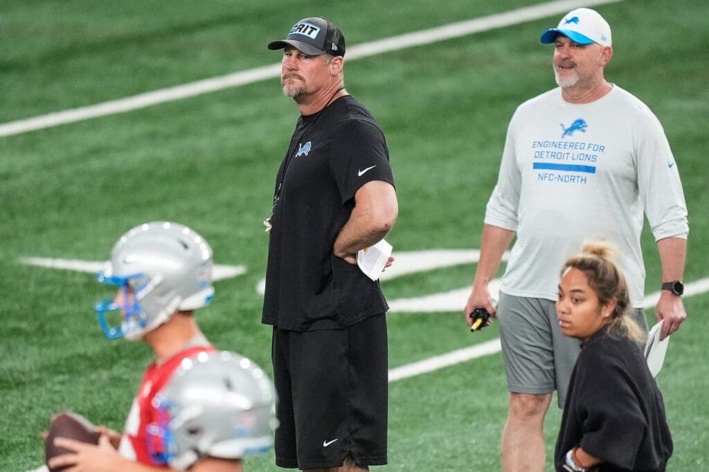 Detroit Lions head coach Dan Campbell, center, and offensive coordinator John Morton watch practice during OTAs at Meijer Performance Center in Allen Park on Thursday, June 5, 2025.