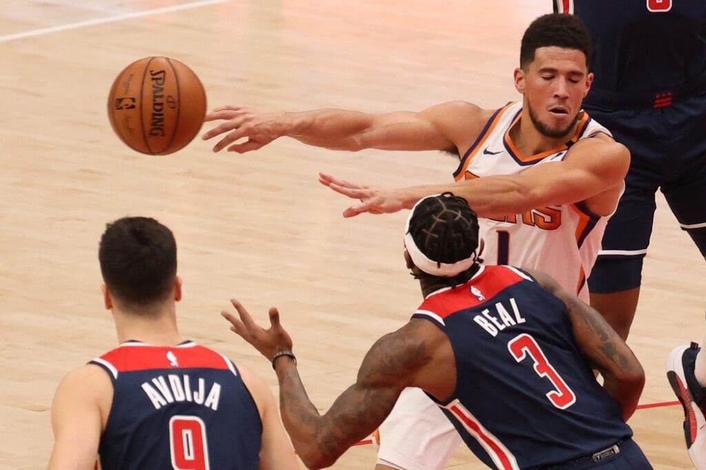 Jan 11, 2021; Washington, District of Columbia, USA; Phoenix Suns guard Devin Booker (1) passes the ball as Washington Wizards guard Bradley Beal (3) defends in t he third in the fourth quarter at Capital One Arena.