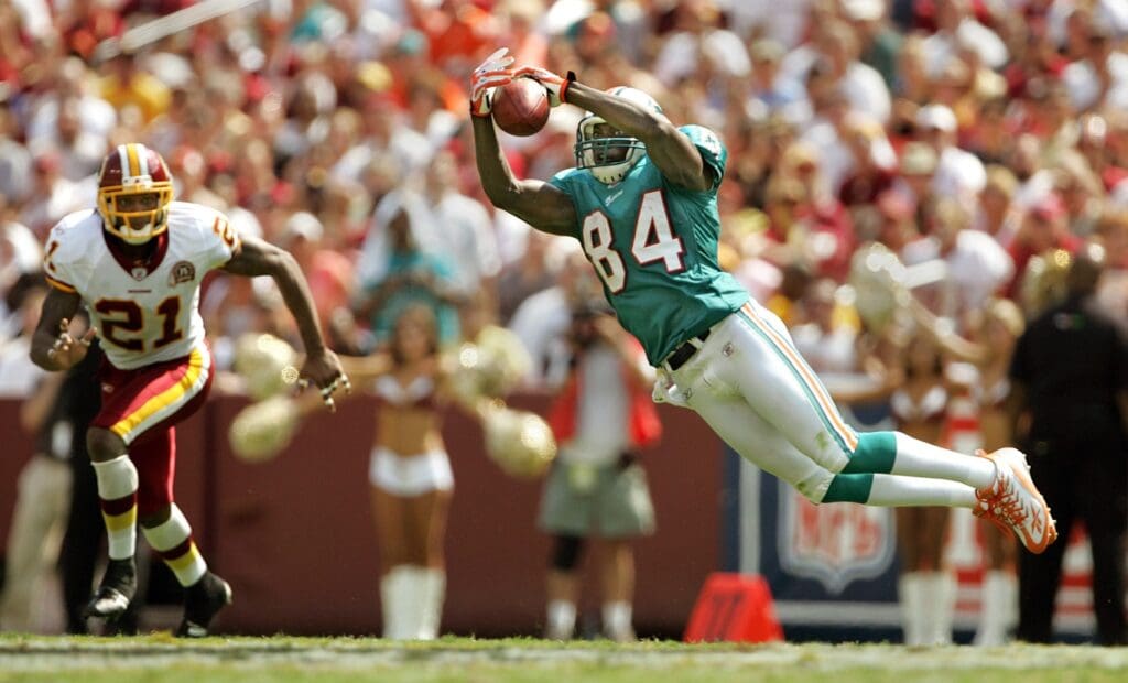 Dolphins receiver Chris Chambers (84) makes a leaping catch for a first down as Redskins safety Sean Taylor defends in the second quarter of an undated game. 090907 Spt Fins Ae 18 Jpg