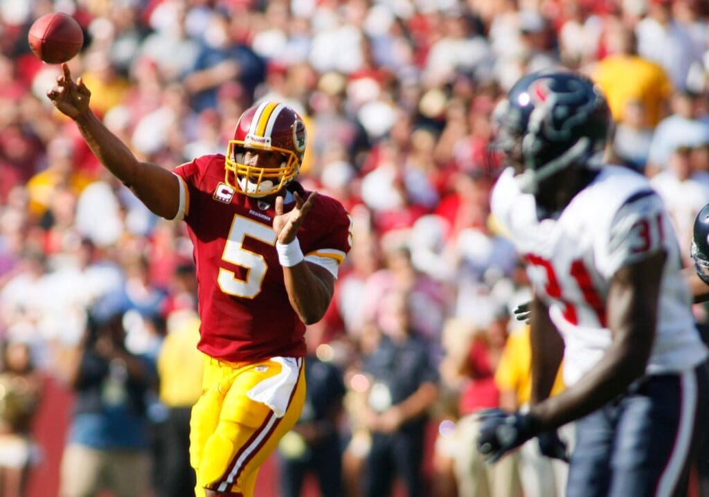 September 19, 2010; Landover, MD, USA; Washington Redskins quarterback Donovan McNabb (5) passes the ball as Houston Texans safety Bernard Pollard (31) chases in the second quarter at FedEx Field.