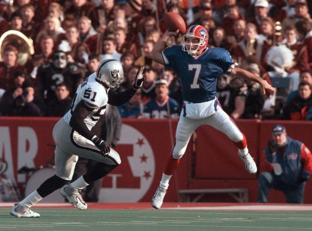 -(Staff Photo/Jamie Germano--In true Flutie form, Doug Flutie leaps high to get a pass over Raiders LB Lance Johnstone. The Bills beat the Raiders 44-21.