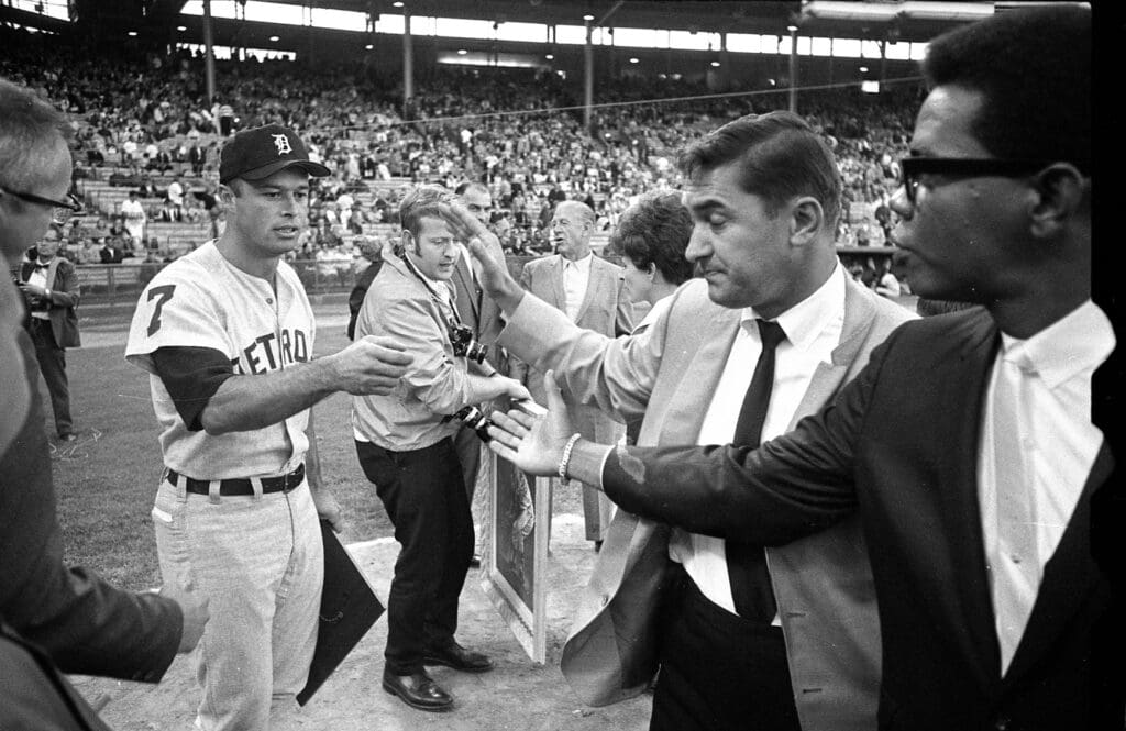 Eddie Mathews reaches out to shake hands with former Braves teammates Johnny Logan
