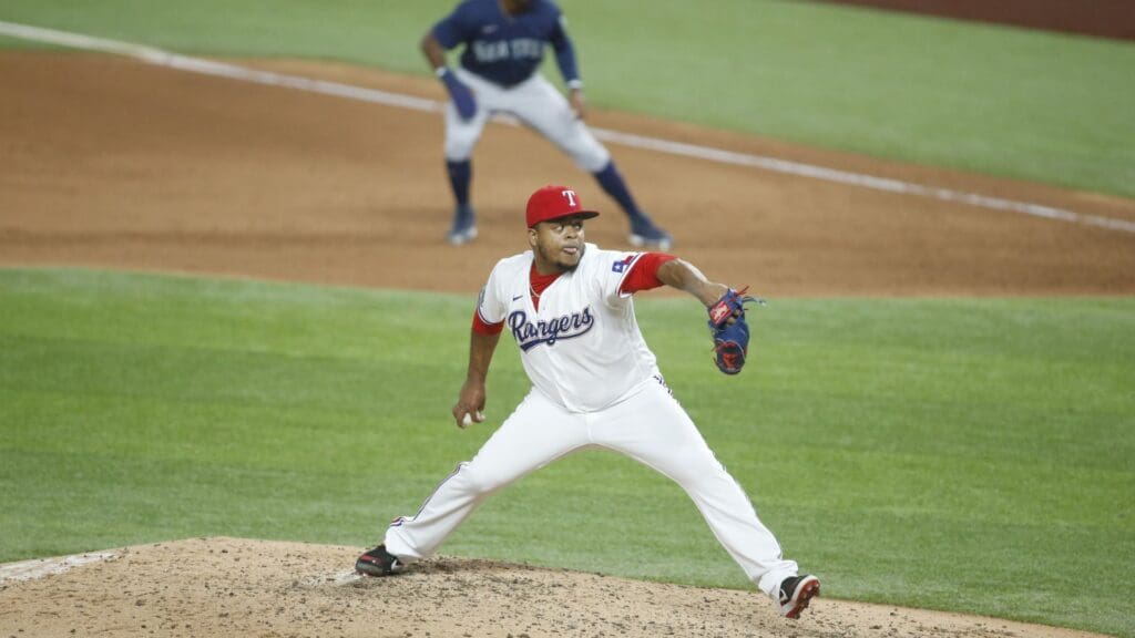 Aug 11, 2020; Arlington, Texas, USA; Texas Rangers starting pitcher Edinson Volquez (36) pitches in the fifth inning as Seattle Mariners center fielder Kyle Lewis (1) takes a lead off first base at Globe Life Field.