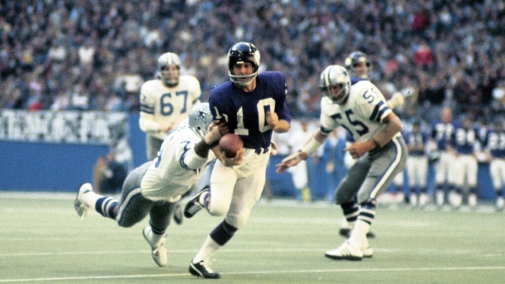 Dec 30, 1973; Dallas, TX, USA; FILE PHOTO; Minnesota Vikings quarterback Fran Tarkenton (10) scrambles away from Dallas Cowboys defensive tackle Jethro Pugh (75) and Leroy Jordan (55) during the 1973 NFC Championship Game at Texas Stadium. The Vikings defeated the Cowboys 27-10.