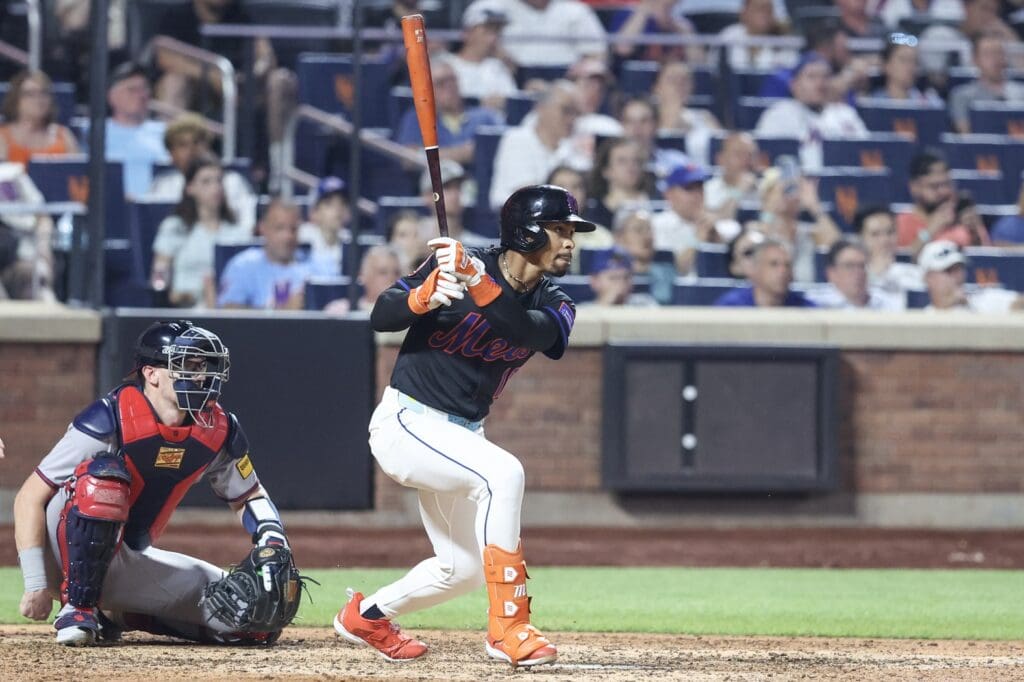 Jun 23, 2025; New York City, New York, USA; New York Mets shortstop Francisco Lindor (12) hits a single in the eighth inning against the Atlanta Braves at Citi Field.