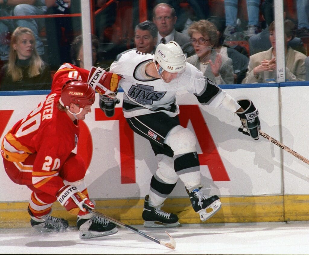 Nov 8, 1989; Inglewood, CA; USA; FILE PHOTO; Los Angeles Kings forward Dave Taylor (right) is defended by Calgary Flames defenseman Gary Suter (20) at the Great Western Forum. Behind the glass president Ronald Reagan and 1st lady Nancy Reagan.