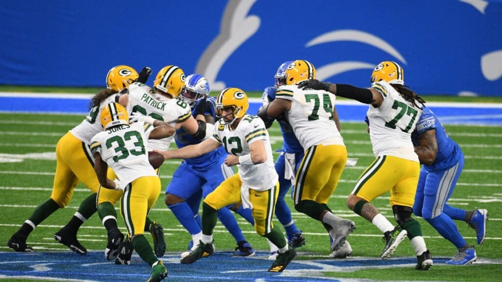 Dec 13, 2020; Detroit, Michigan, USA; Green Bay Packers quarterback Aaron Rodgers (12) hands off to running back Aaron Jones (33) during the fourth quarter against the Detroit Lions at Ford Field