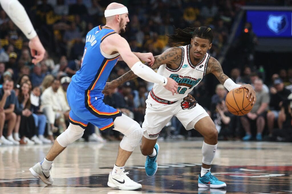 Apr 24, 2025; Memphis, Tennessee, USA; Memphis Grizzlies guard Ja Morant (12) drives to the basket as Oklahoma City Thunder guard Alex Caruso (9) defends during the second quarter during game three for the first round of the 2024 NBA Playoffs at FedExForum.