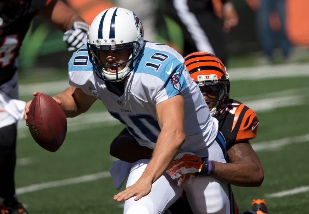 Sep 21, 2014; Cincinnati, OH, USA; Tennessee Titans quarterback Jake Locker (10) is sacked by Cincinnati Bengals cornerback Darqueze Dennard (21) at Paul Brown Stadium. The Bengals won 33-7.