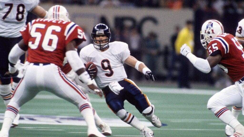 Jan 26, 1986; New Orleans, LA, USA; FILE PHOTO; Chicago Bears quarterback Jim McMahon (9) runs with the ball against New England Patriots linebacker Andre Tippett (56) during Super Bowl XX at the Superdome. The Bears defeated the Patriots 46-10.