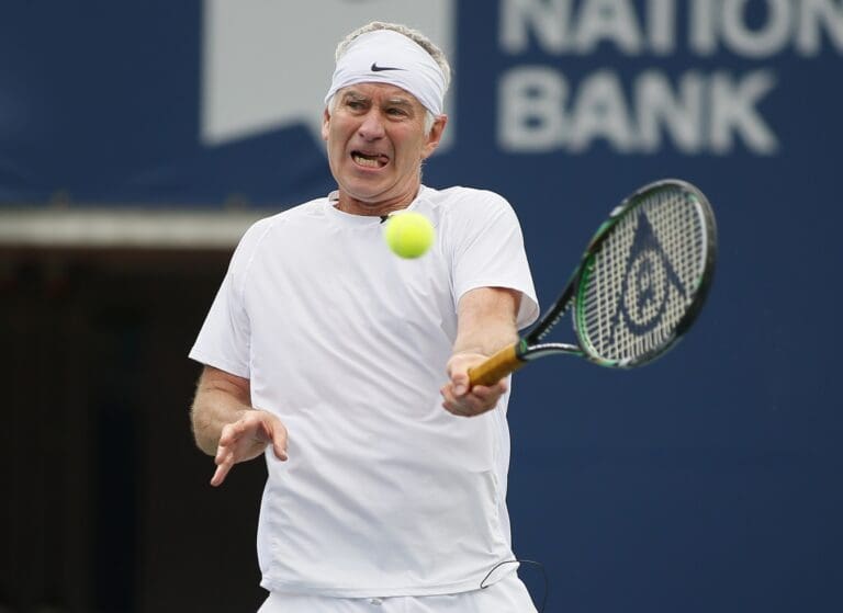 Aug 11, 2013; Toronto,ON, Canada; John McEnroe (USA) returns a ball to Jim Courier (USA) (not pictured) during the Legends exhibition match at the Rexall Centre.