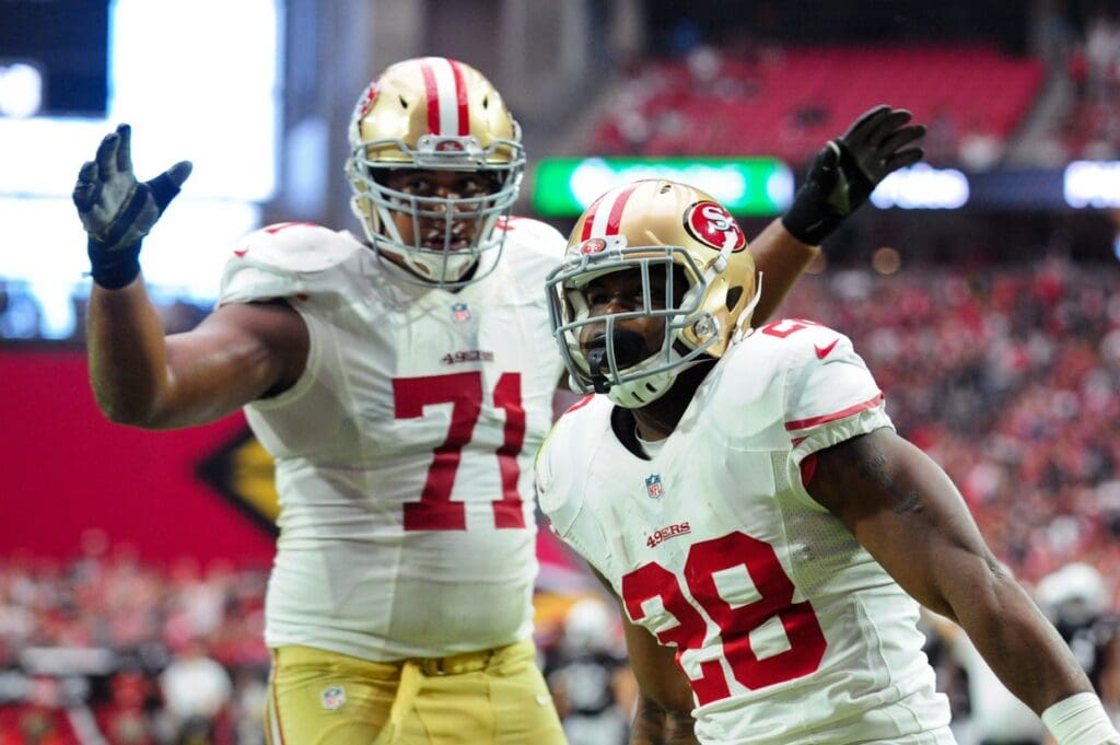 Sep 21, 2014; Glendale, AZ, USA; San Francisco 49ers running back Carlos Hyde (28) celebrates with tackle Jonathan Martin (71) after scoring a 6 yard touchdown during the first half against the Arizona Cardinals at University of Phoenix Stadium.