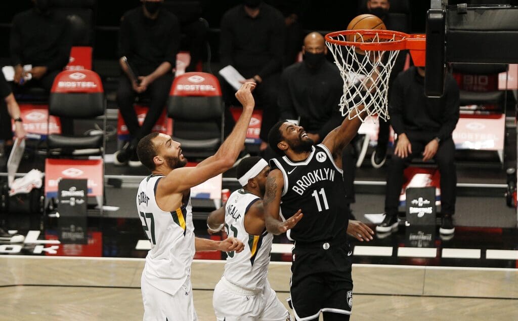 Jan 5, 2021; Brooklyn, New York, USA; Brooklyn Nets guard Kyrie Irving (11) shoots against Utah Jazz center Rudy Gobert (27) during the first half at Barclays Center.