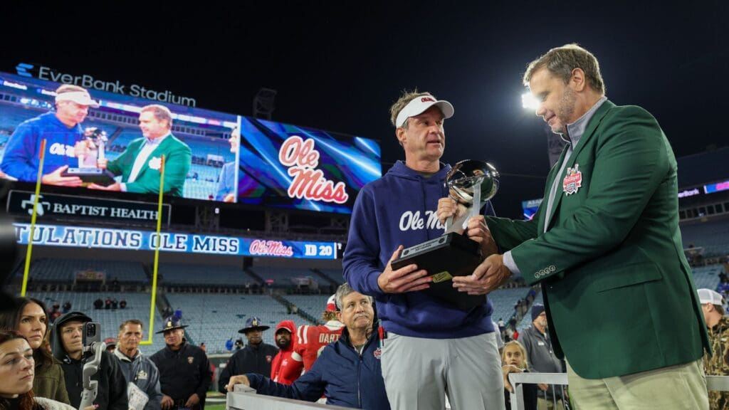 Jan 2, 2025; Jacksonville, FL, USA; Mississippi Rebels head coach Lane Kiffin is givent the Gator Bowl trophy after beating the Duke Blue Devils at EverBank Stadium.