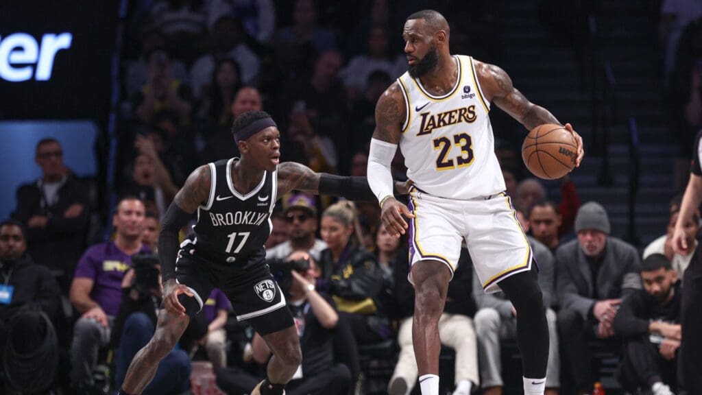 Mar 31, 2024; Brooklyn, New York, USA; Los Angeles Lakers forward LeBron James (23) dribbles against Brooklyn Nets guard Dennis Schroder (17) during the first half at Barclays Center
