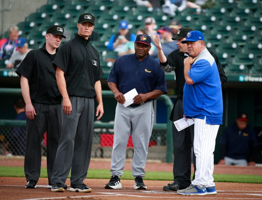 Iowa Cubs manager Marty Pevey, right, visits with umpire Cody Oakes, Toledo manager Lloyd McClendon, and umpires Dillon Wilson and Matt Winter prior to the start of the Triple-A baseball game at Principal Park in Des Moines on Tuesday, April 12, 2022. Iowacubs 20220412 Bh