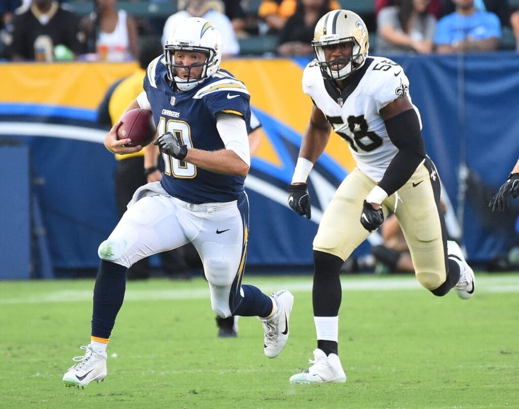 Aug 20, 2017; Carson, CA, USA; Los Angeles Chargers quarterback Kellen Clemens (10) runs for a first down as he is chases by New Orleans Saints defensive end Obum Gwacham (58) in the first half at StubHub Center. 