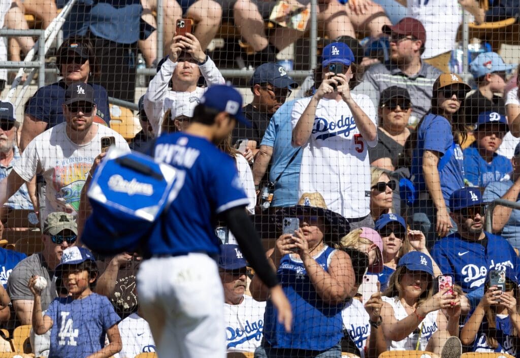 Mar 2, 2025; Phoenix, Arizona, USA; Los Angeles Dodgers fans take pictures as designated hitter Shohei Ohtani (17) leaves the game against the Chicago White Sox during spring training at Camelback Ranch-Glendale
