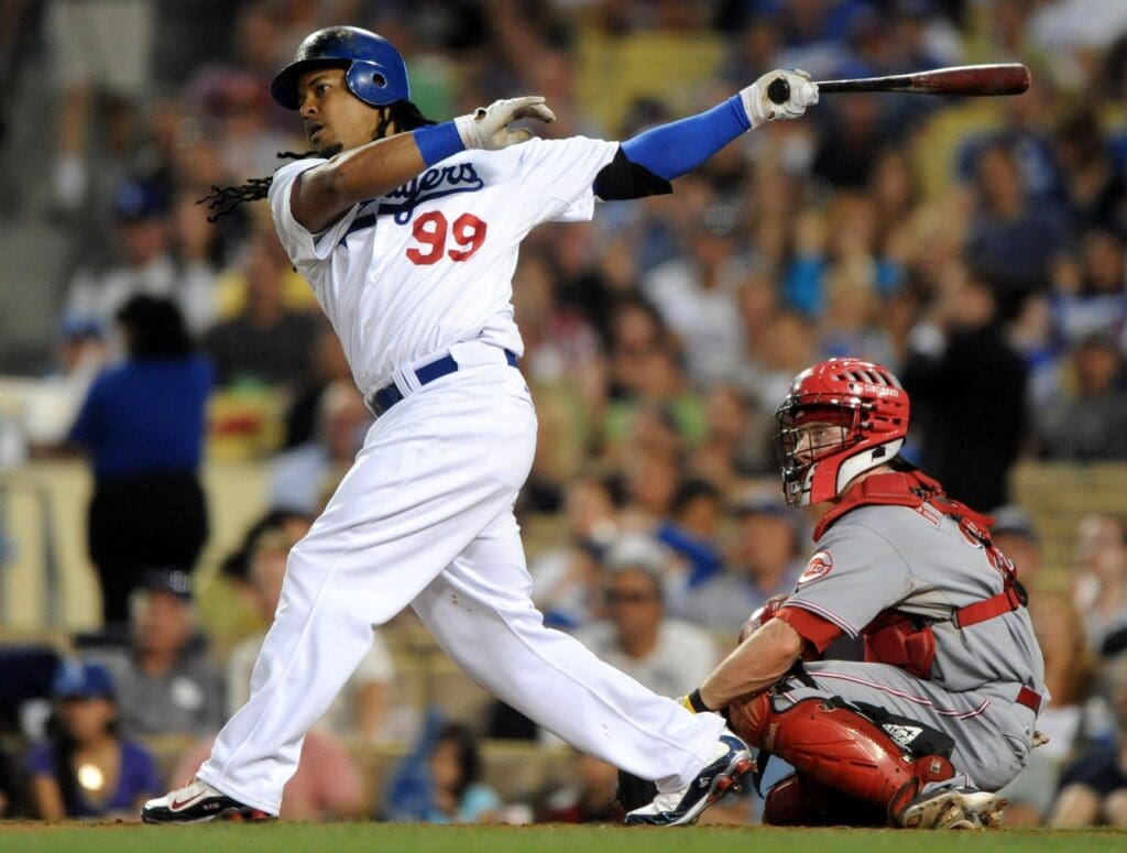 Jul 20, 2009; Los Angeles, CA, USA; Los Angeles Dodgers left fielder Manny Ramirez (99) follows through on a two-run home run in the second inning as Cincinnati Reds catcher Ryan Hanigan (29) look on at Dodger Stadium.