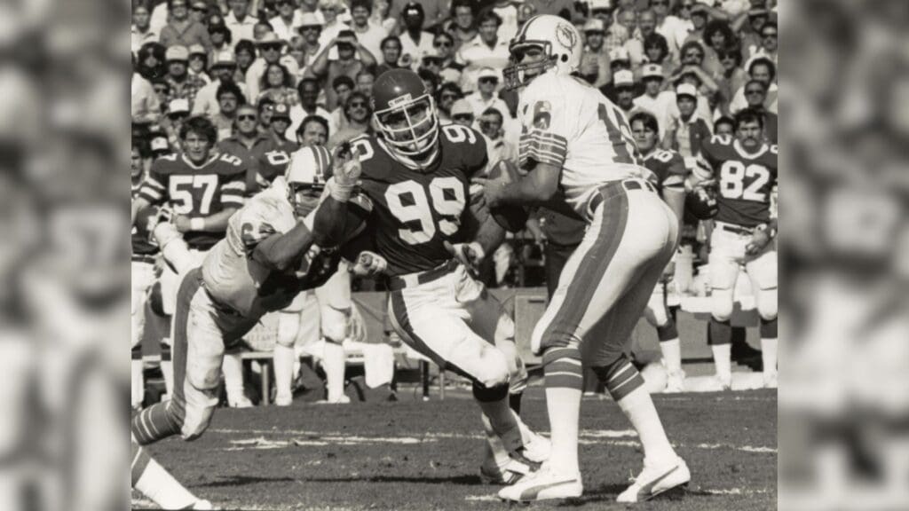 Dec. 18, 1982; Miami, FL, USA; FILE PHOTO; Miami Dolphins quarterback David Woodley (16) is pursued by New York Jets defensive end Mark Gastineau (99) at the Orange Bowl.