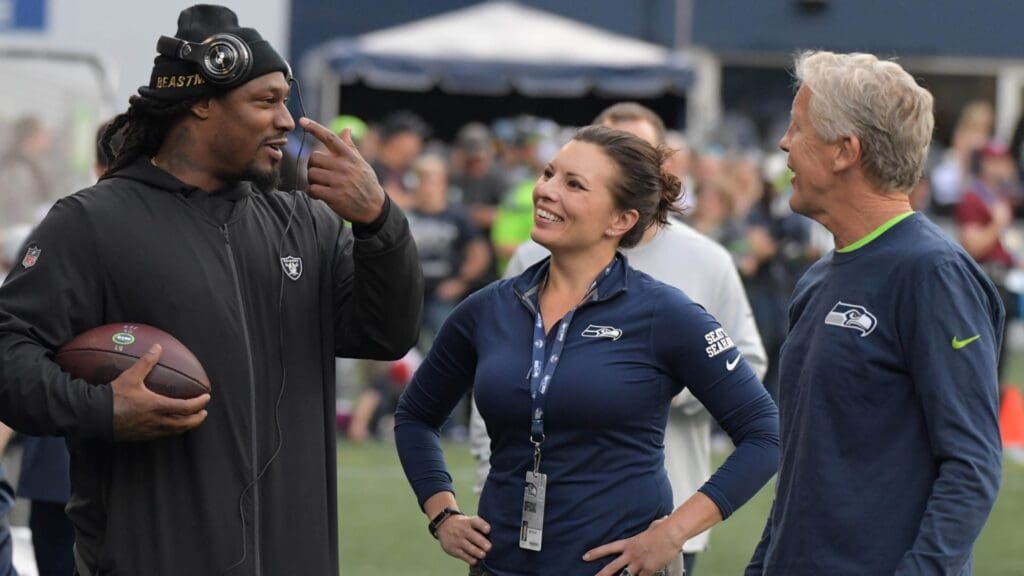 Aug 30, 2018; Seattle, WA, USA; Oakland Raiders running back Marshawn Lynch (left) talks with Seahawks radio siideline reporter Jen Mueller (center0 nad Seahawks coach Pete Carroll during a preseason game at CenturyLink Field.