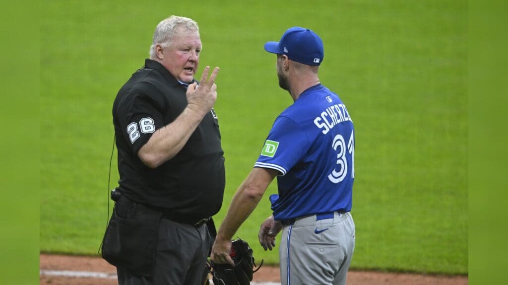 Jun 25, 2025; Cleveland, Ohio, USA; Toronto Blue Jays starting pitcher Max Scherzer (31) talks to home plate umpire Bill Miller (26) after walking a batter after a pitch clock violation in the fifth inning against the Cleveland Guardians at Progressive Field.