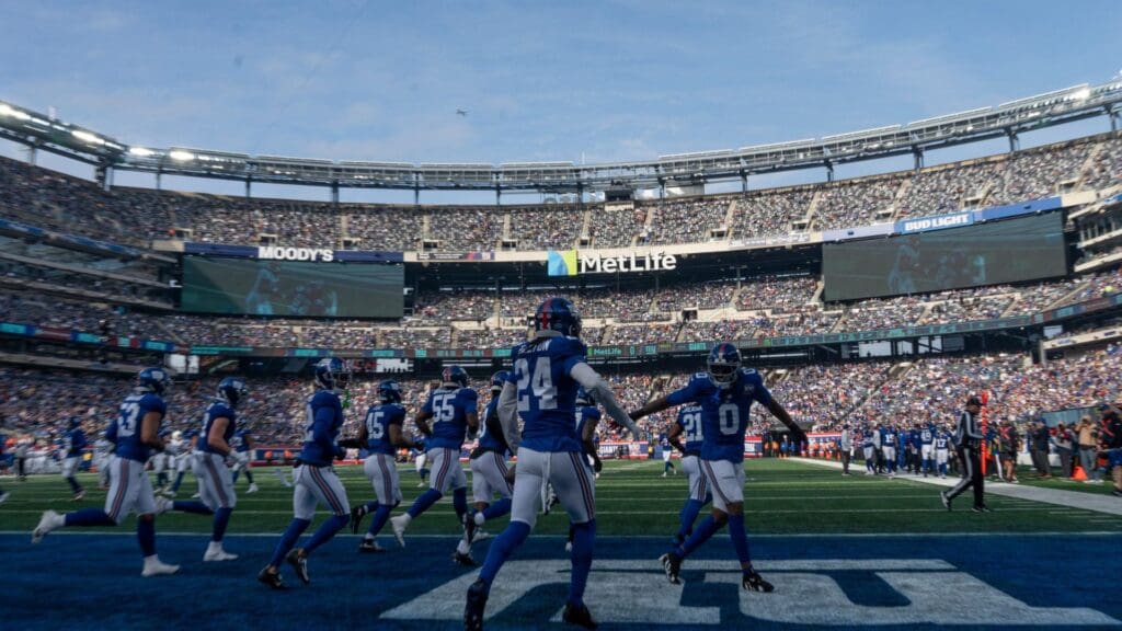 New York Giants linebacker Brian Burns (0) and New York Giants safety Dane Belton (24) celebrate after an interception during a game between New York Giants and Indianapolis Colts at MetLife Stadium on Sunday, Dec. 29, 2024.