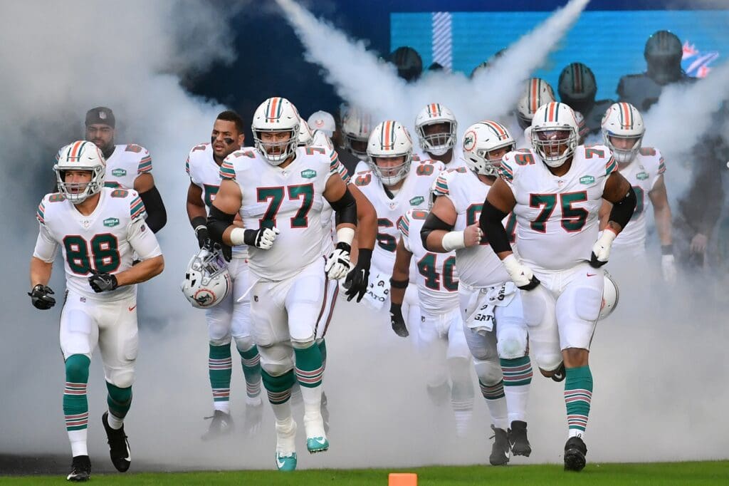 Nov 15, 2020; Miami Gardens, Florida, USA; Miami Dolphins tight end Mike Gesicki (88), offensive tackle Jesse Davis (77) and offensive guard Ereck Flowers (75) lead the team on to the field prior to the game against the Los Angeles Chargers at Hard Rock Stadium