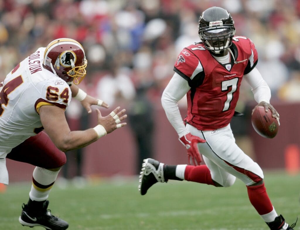 Dec 3, 2006; Landover, MD, USA; Atlanta Falcons quarterback (7) Michael Vick rolls out of the pocket as Washington Redskins defensive tackle (64) Kedric Golston gives chase in the second quarter at FedEx Field in Landover, MD.