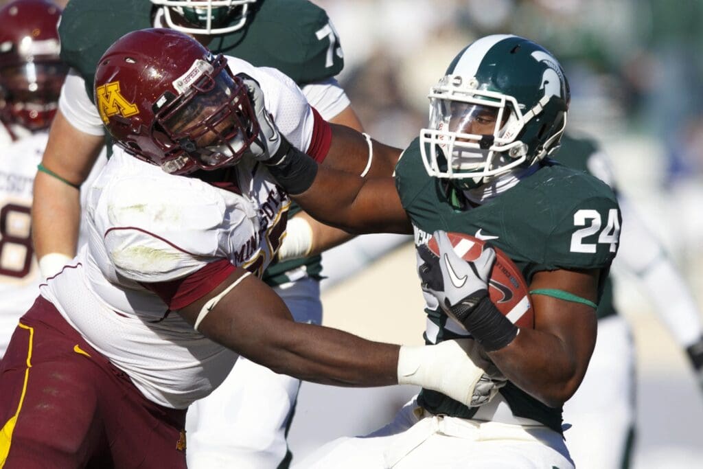 Nov 6, 2010; East Lansing, MI, USA; Michigan State Spartans running back LeVeon Bell (24) stiff arms Minnesota Golden Gophers defensive end Anthony Jacobs (97) during the in the second half of the game against the Minnesota Golden Gophers at Spartan Stadium.