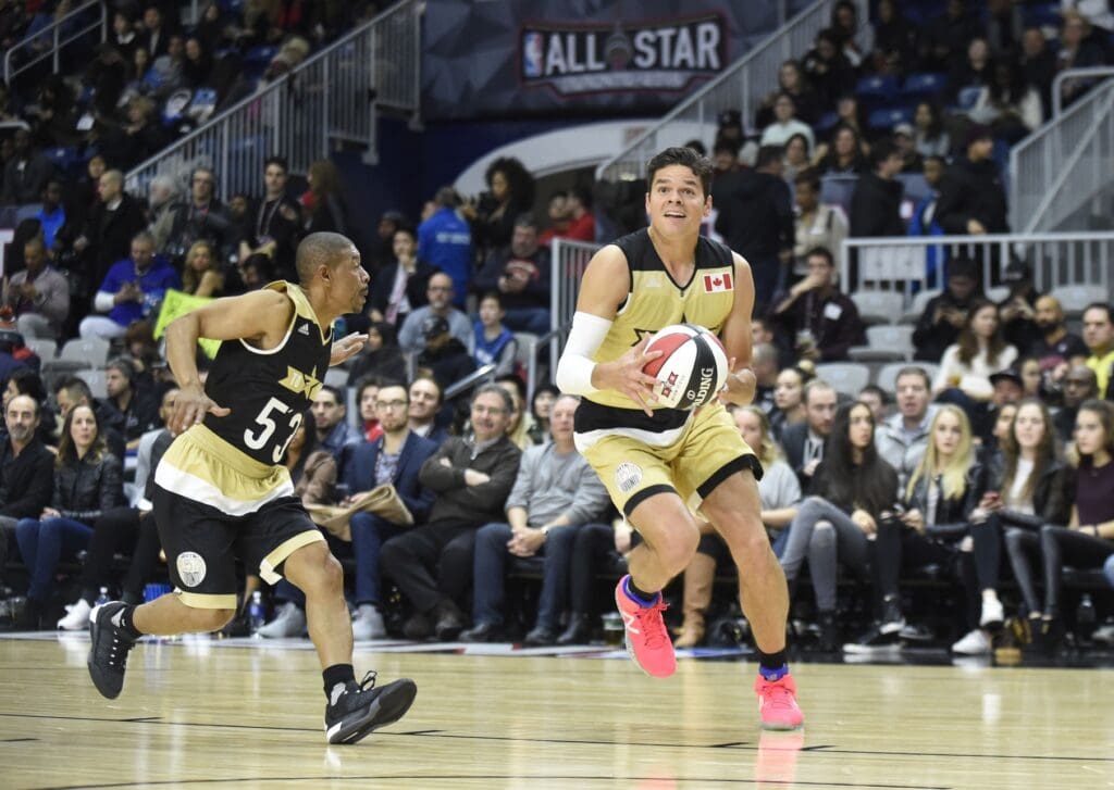 Feb 12, 2016; Toronto, Ontario, Canada; Canada player Milos Raonic (27) drives to the basket against USA player Muggsy Bogues (5'3) during the All-Star celebrity basketball game at Ricoh Coliseum.