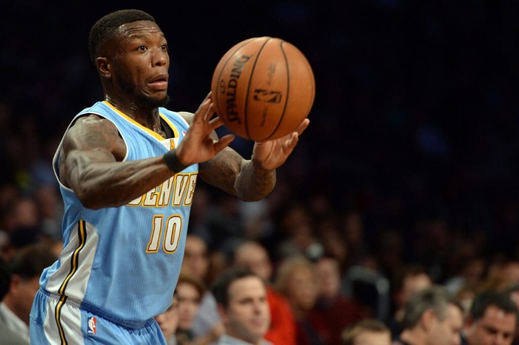 Dec 3, 2013; Brooklyn, NY, USA; Denver Nuggets point guard Nate Robinson (10) makes a pass against the Brooklyn Nets during the first half at Barclays Center.