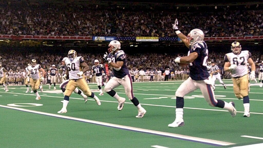 Feb 3, 2002; New Orleans, Louisiana, USA; New England Patriots cornerback Ty Law (24) runs for a touchdown after intercepting a pass against St. Louis Rams quarterback Kurt Warner in the second quarter of Super Bowl XXXV at the Louisiana Superdome.