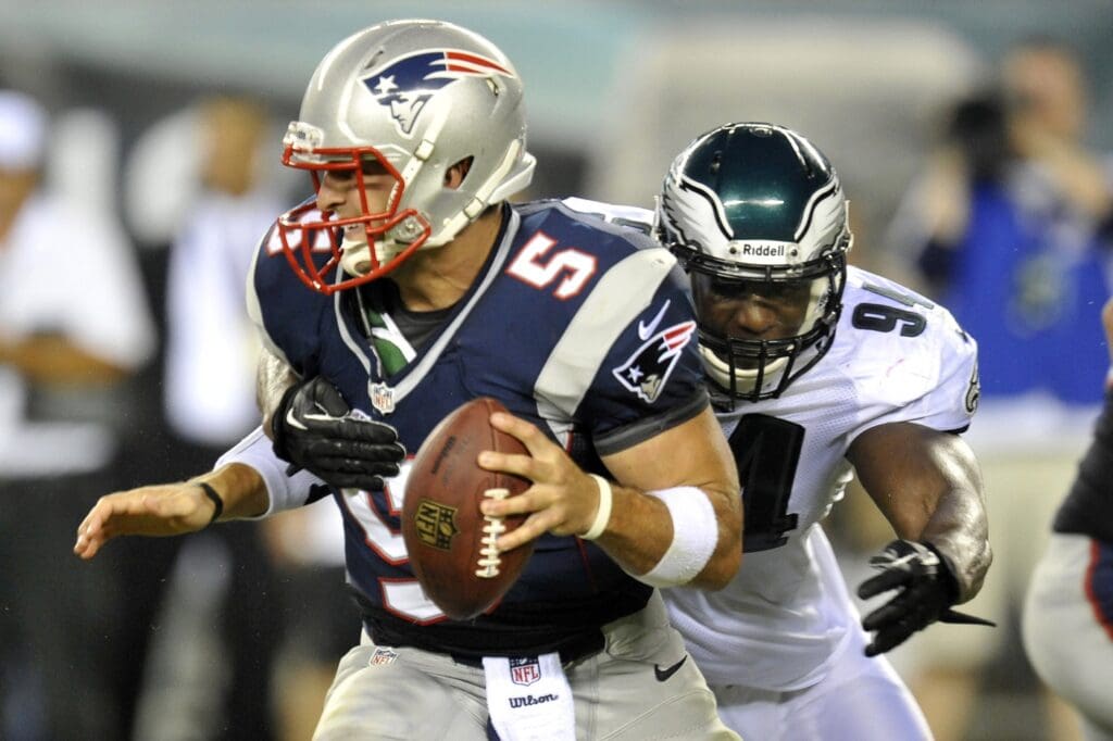 Aug 9, 2013; Philadelphia, PA, USA; New England Patriots quarterback Tim Tebow (5) is sacked by Philadelphia Eagles linebacker Chris McCoy (94) during the second half of a preseason game at Lincoln Financial Field. The Patriots won 31-22.