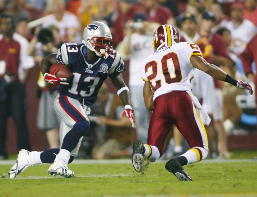 August 28, 2009; Landover, MD, USA; New England Patriots wide receiver Joey Galloway (13) carries as Washington Redskins cornerback Justin Tryon (20) chases in the first quarter at FedEx Field in Landover, Maryland. The Patriots won 27-24.
