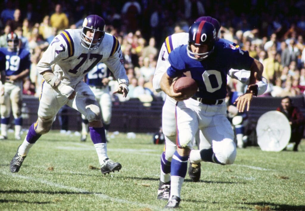 Sep 21, 1969; Bronx, NY, USA; FILE PHOTO; New York Giants quarterback Fran Tarkenton (10) is pursued by Minnesota Vikings defensive tackle Gary Larsen (77) at Yankee Stadium.