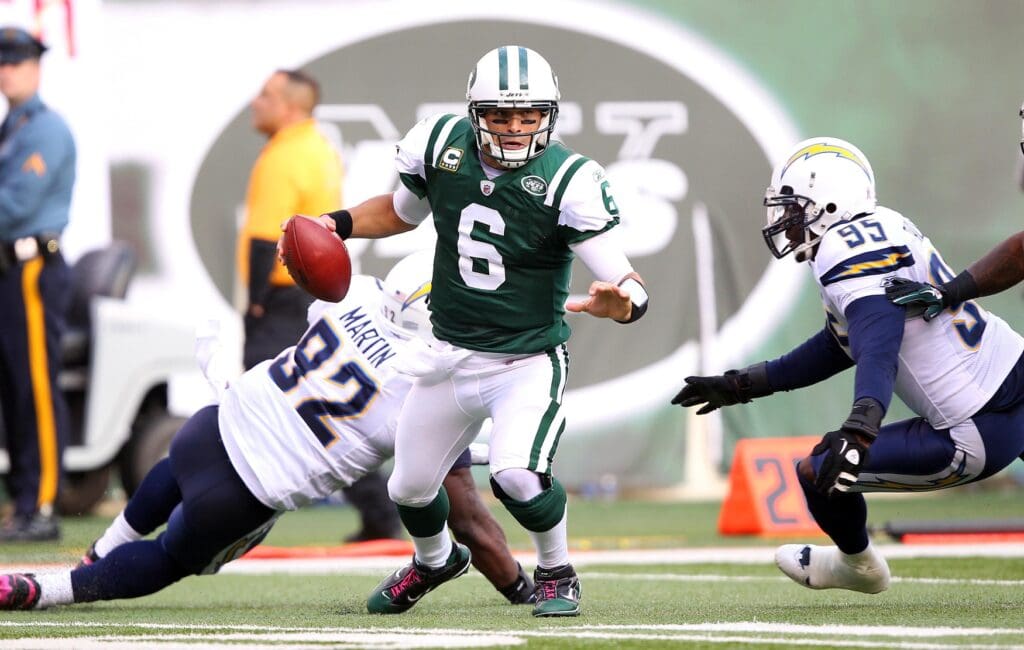 Oct 23, 2011; East Rutherford, NJ, USA; New York Jets quarterback Mark Sanchez (6) scrambles away from San Diego Chargers defensive end Vaughn Martin (92) during the game at MetLife Stadium.