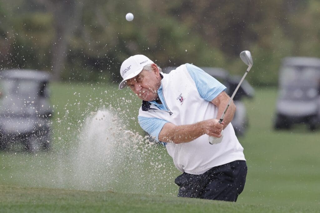 Dec 16, 2023; Orlando, Florida, USA; Nick Price hits from the bunker on the third hole during the PNC Championship at The Ritz-Carlton Golf Club. 