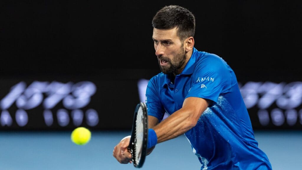 Jan 21, 2025; Melbourne, Victoria, Australia; Novak Djokovic of Serbia plays a backhand during his match against Carlos Alcaraz of Spain in the quarterfinals of the men's singles at the 2025 Australian Open at Melbourne Park