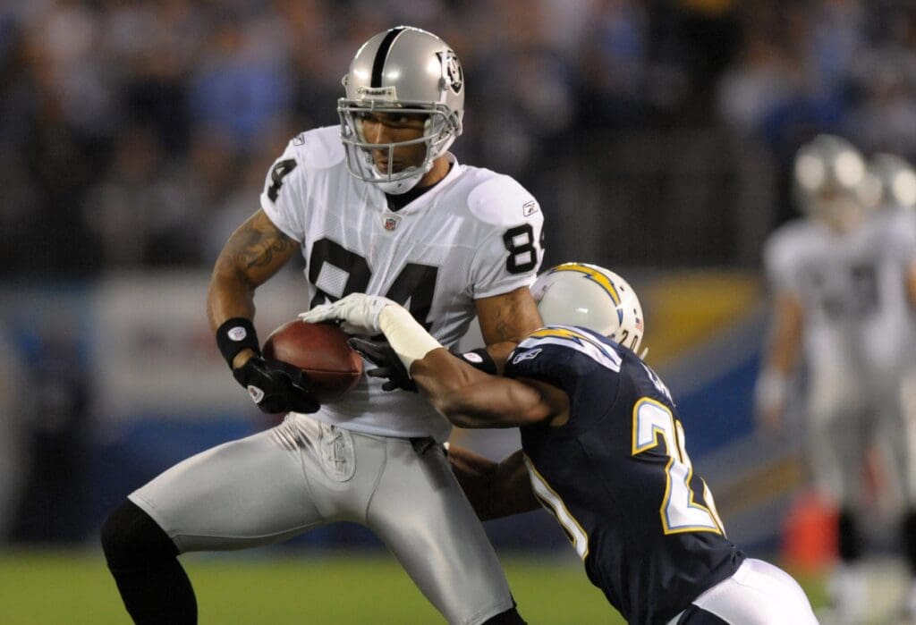 Nov 10, 2011; San Diego, CA, USA; Oakland Raiders receiver T.J. Houshmandzadeh (84) tries to elude San Diego Chargers cornerback Antoine Cason (20) at Qualcomm Stadium. The Raiders defeated the Chargers 24-17.