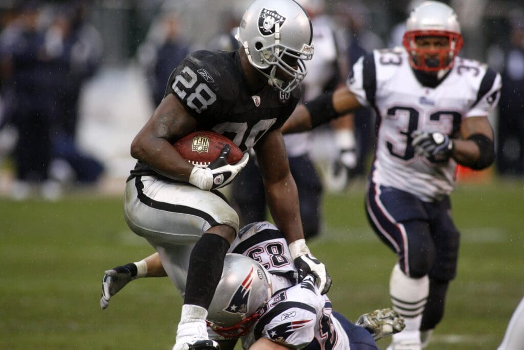 Dec. 14, 2008; Oakland, CA, USA; Oakland Raiders safety Gibril Wilson (28) runs back in interception past New England Patriots wide receiver Wes Welker (83) in the second quarter at Oakland-Alameda County Coliseum in Oakland, CA. The Patriots defeated the Raiders 49-21