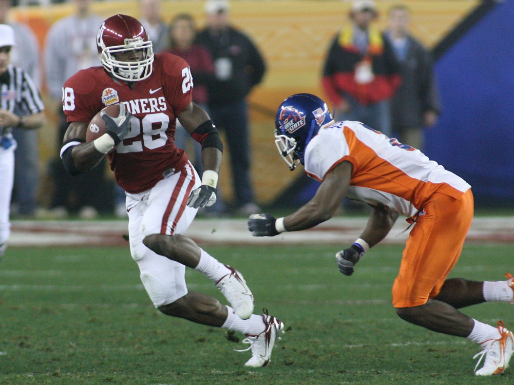 Jan 1,2007; Glendale, AZ, USA; Oklahoma Sooners running back (28) Adrian Peterson runs from a Boise State Broncos defender during the first quarter in the Fiesta Bowl at University of Phoenix Stadium in Glendale, Arizona.