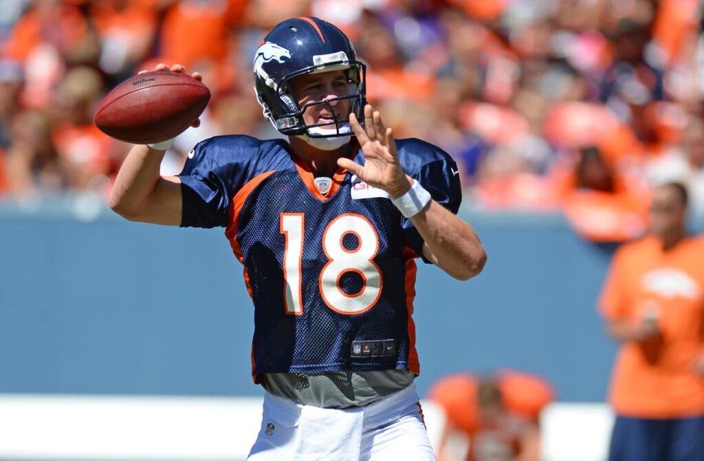 Aug 2, 2014; Denver, CO, USA; Denver Broncos quarterback Peyton Manning (18) prepares to throw as he warms up prior to the start of a scrimmage at Sports Authority Field.