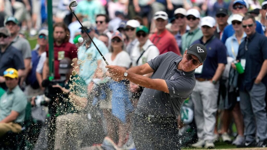 Phil Mickelson plays a shot from a bunker on the seventh hole.