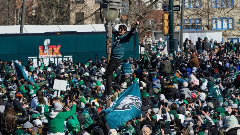 An Eagles fan climbs a light post during the Philadelphia Eagles Super Bowl celebration in front of the Philadelphia Museum of Art, Friday, Feb. 14, 2025.