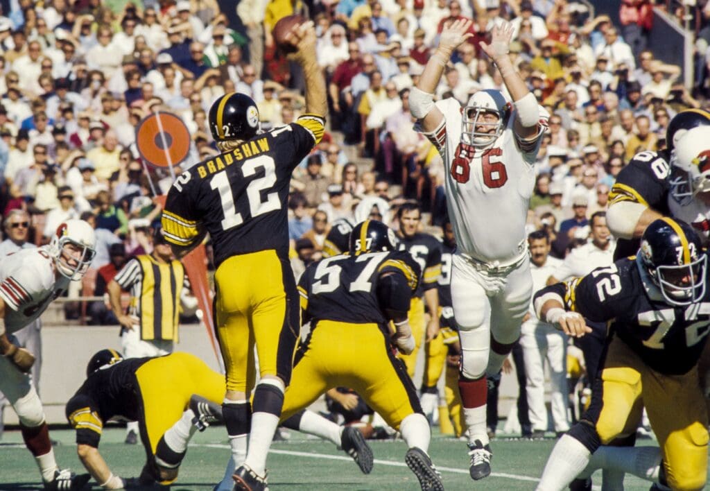 Oct 1, 1972; St. Louis, MO, USA; FILE PHOTO; Pittsburgh Steelers quarterback Terry Bradshaw (12) throws the ball under pressure from St. Louis Cardinals defensive end Don Brumm (86) at Busch Stadium.