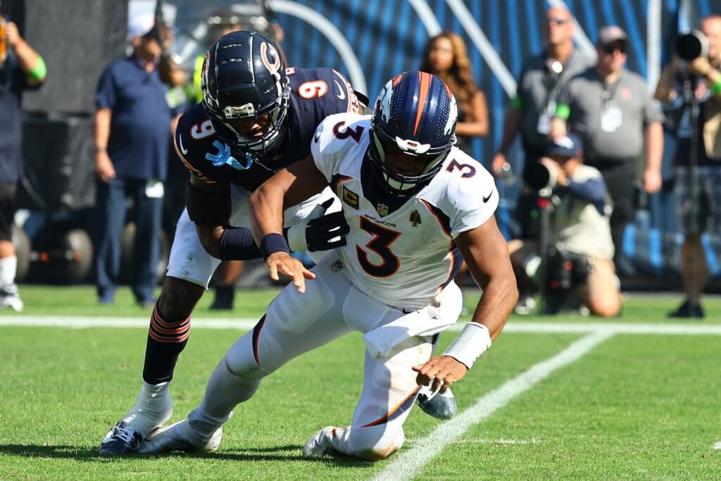Oct 1, 2023; Chicago, Illinois, USA; Chicago Bears safety Jaquan Brisker (9) tackles Denver Broncos quarterback Russell Wilson (3) during the second half at Soldier Field.